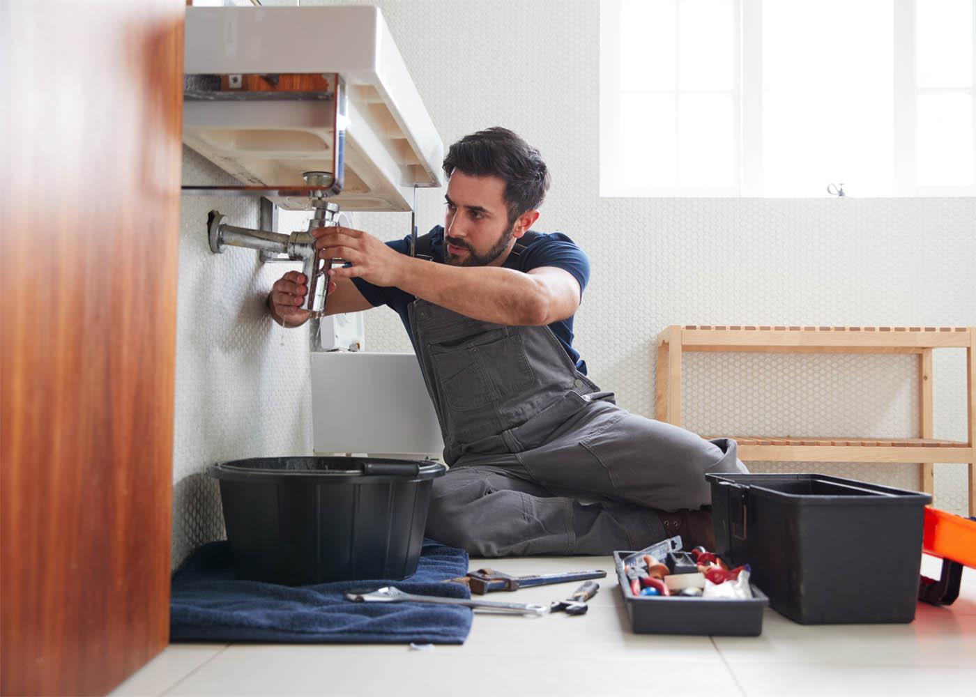 Professional plumber inspecting pipes and plumbing fixtures