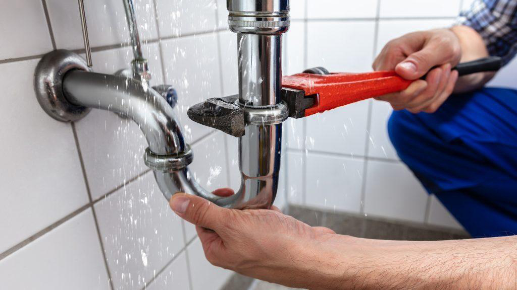 Plumbing specialist carefully inspecting a household water pipe